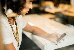 woman looking at mobile phone at desk